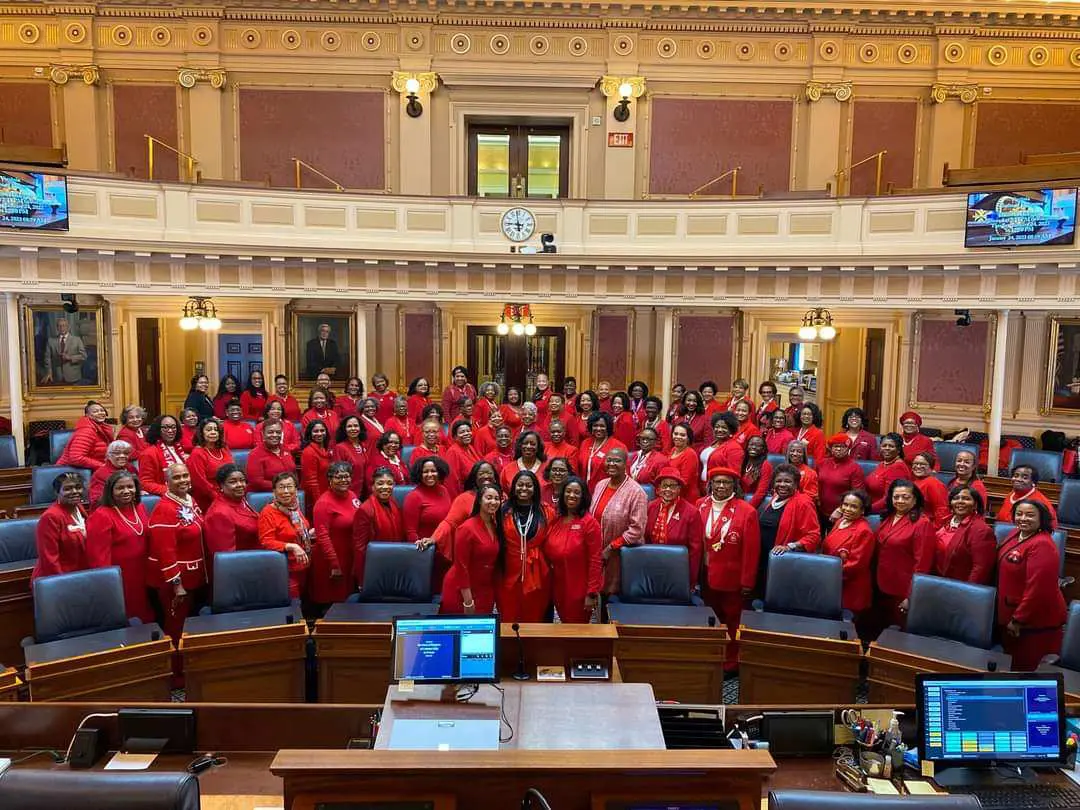 A big conference hall filled with women wearing red dress